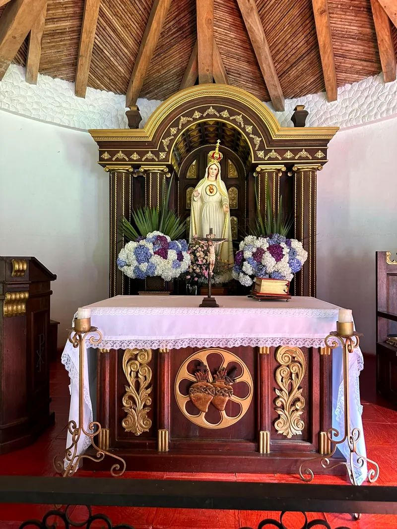 Altar de la Virgen con flores blancas y azules en el Monasterio
